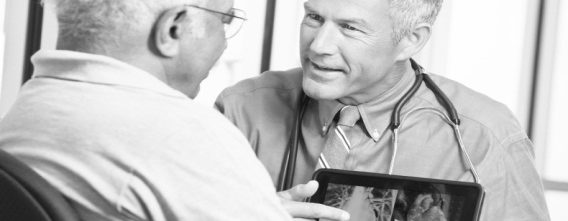 two old men looking at a screen