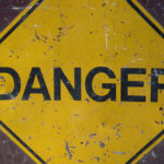 Yellow triangular sign with the words Danger