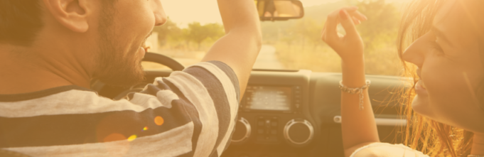Man and woman having fun in convertible with roof down