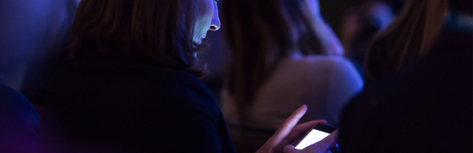 Woman in audience looking at phone