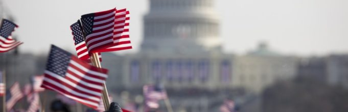 people waving American flags in front of the White House in Washington D.C.