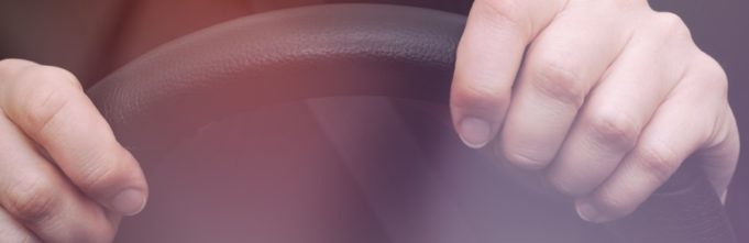 Hands on steering wheel of a car