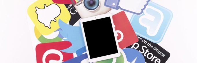 Tablet on a stack of tech logos and icons