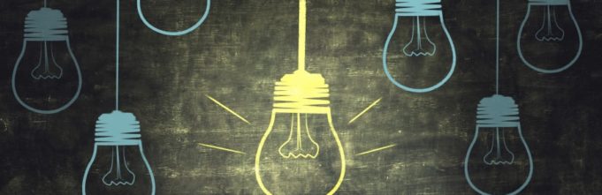 Chalk drawings of light bulbs, one is lit and the others are dim