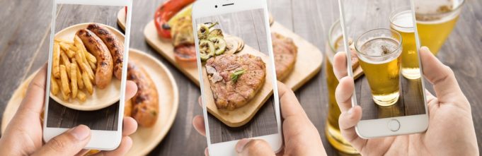 Image of three cell phones taking pictures of food and drinks