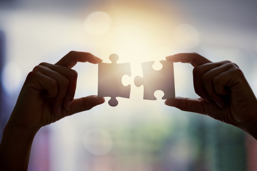A person holding 2 puzzle pieces together | Centro