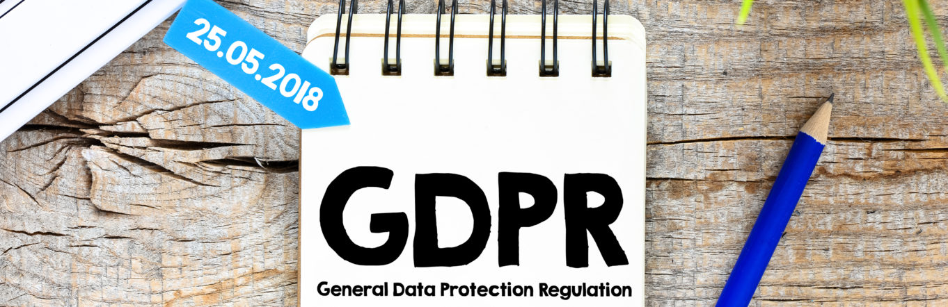 Notepad with GDPR logo sitting on wooden desk