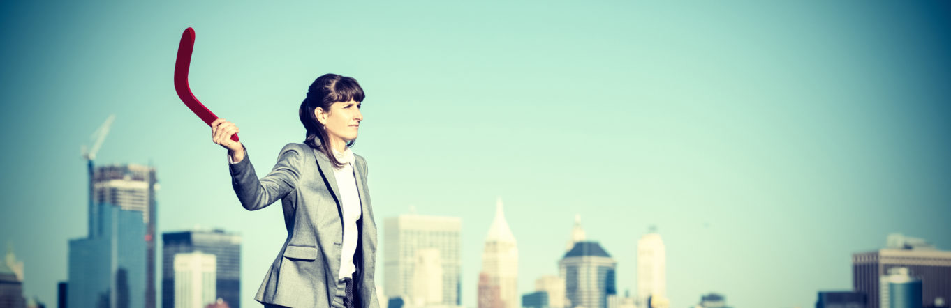 Businesswoman throwing a Boomerang. Investment and gain concept.