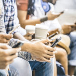 Multicultural friends group using smartphone with coffee at university college break - People hands addicted by mobile smart phone - Technology concept with connected trendy millennials