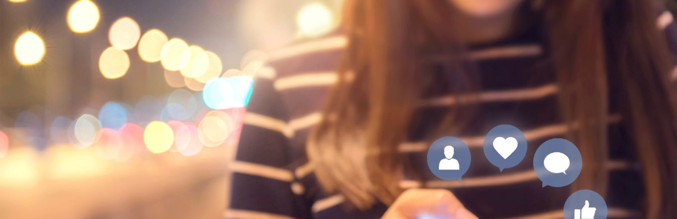 Woman in striped shirt interacting with cellular phone completing social interactions.