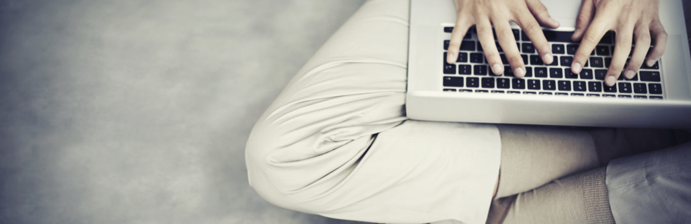 Man sitting cross-legged with a laptop in his lap