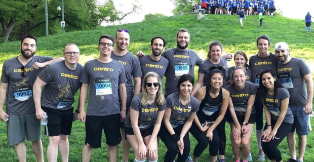 Group photo with people in grey shirts on a sports field