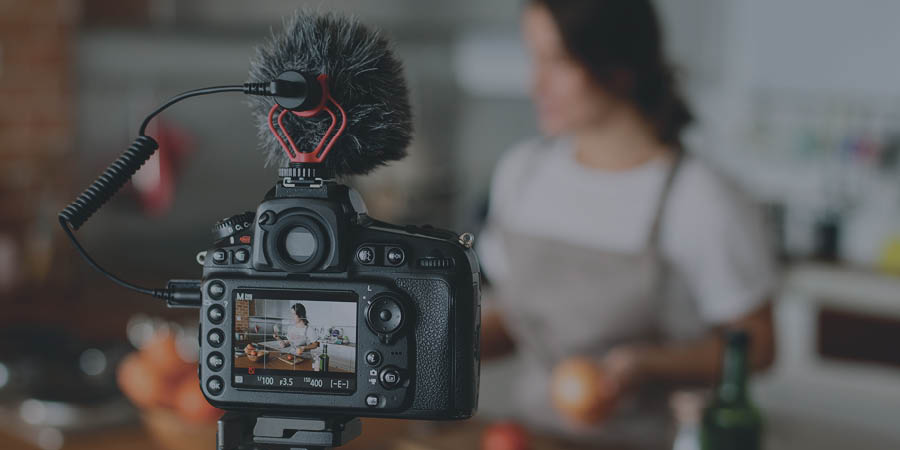 Picture of the screen of a camera with a woman in the background