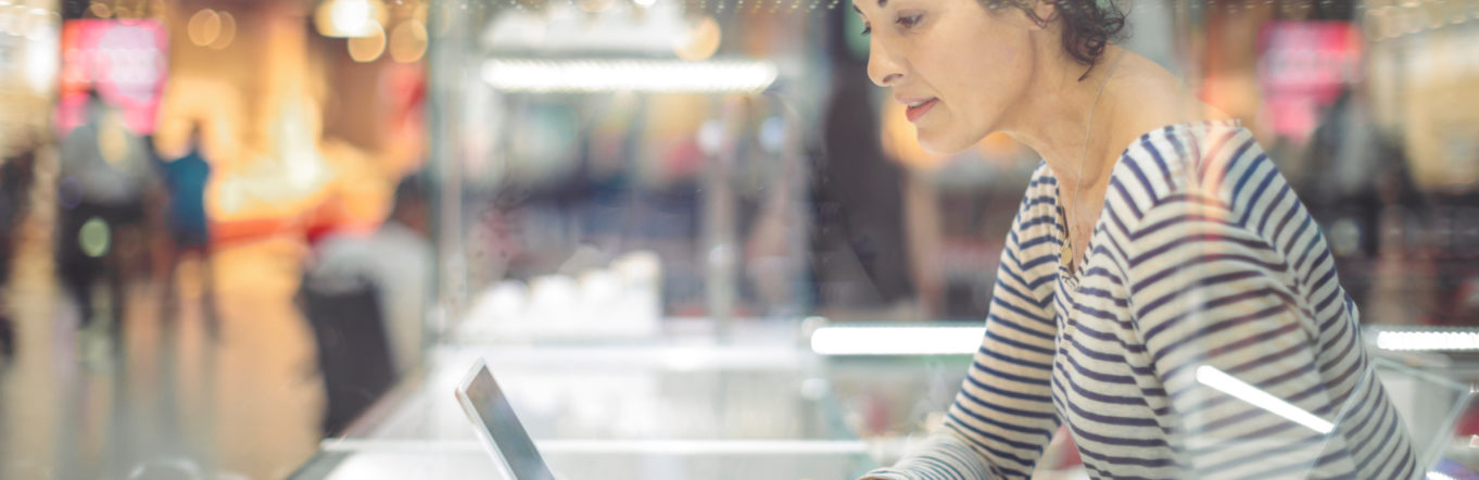 Woman in striped shirt typing on a bluetooth keyboard connected to an iPad.