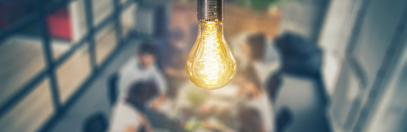 Lightbulb over a blurred office scene