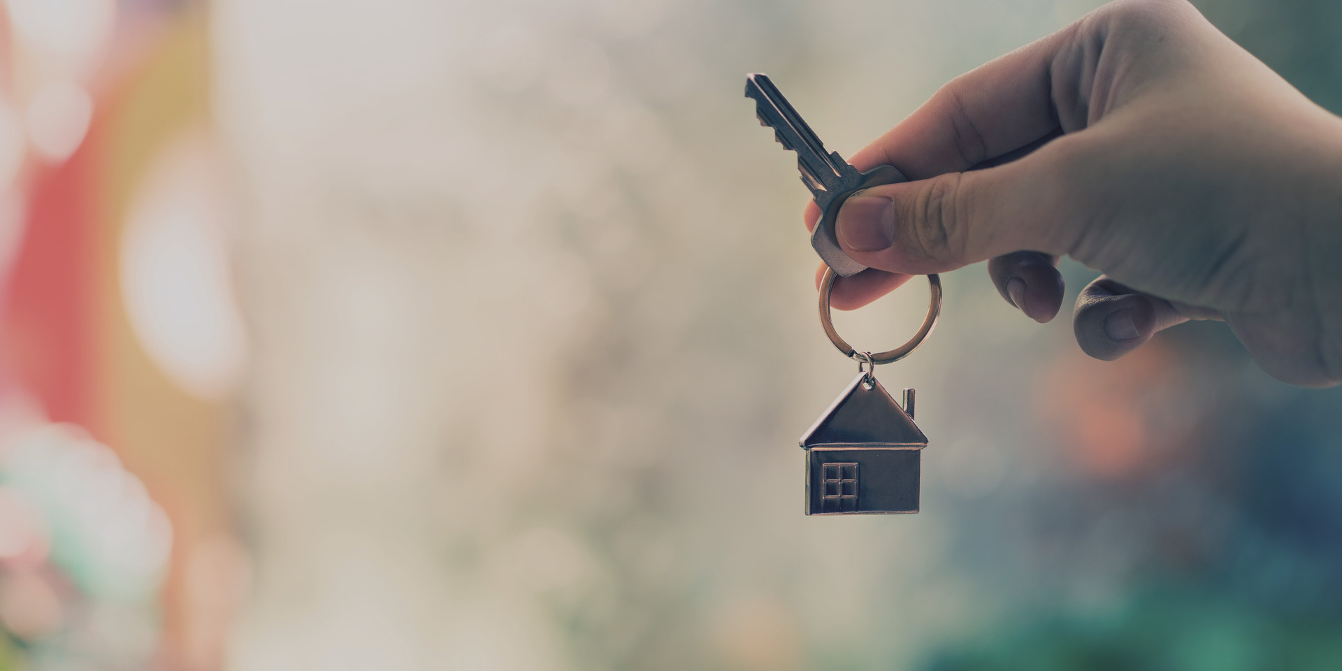 a hand holding a key to a new home