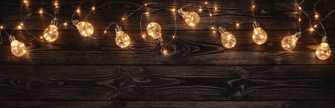 String of festive lights on a wooden background