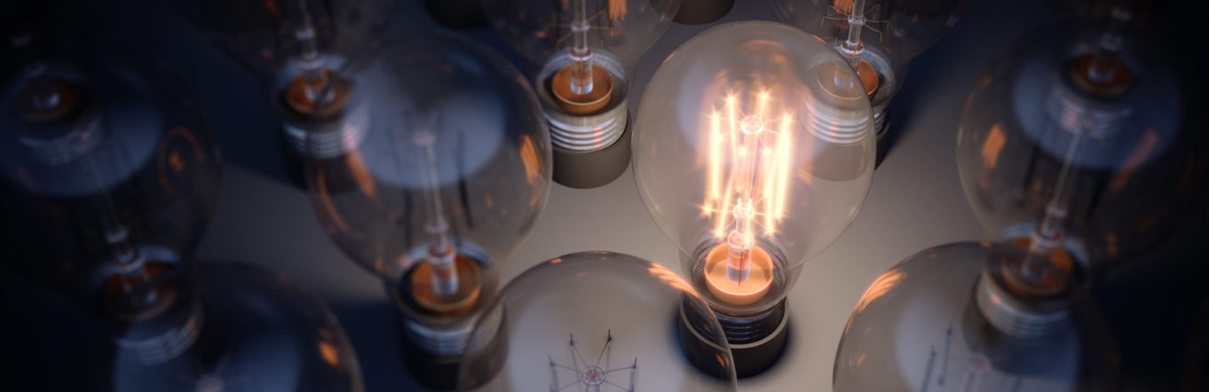 Collection of lightbulbs with one lit up