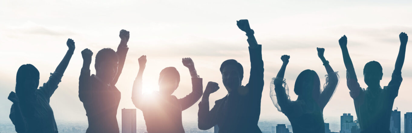 Business people cheering on a roof