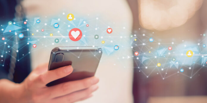 Social media icons swarming around a cell phone