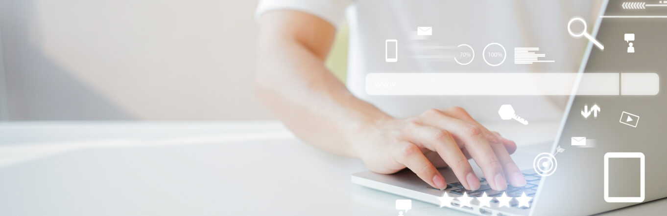 Social media icons hovering around a man working at a laptop