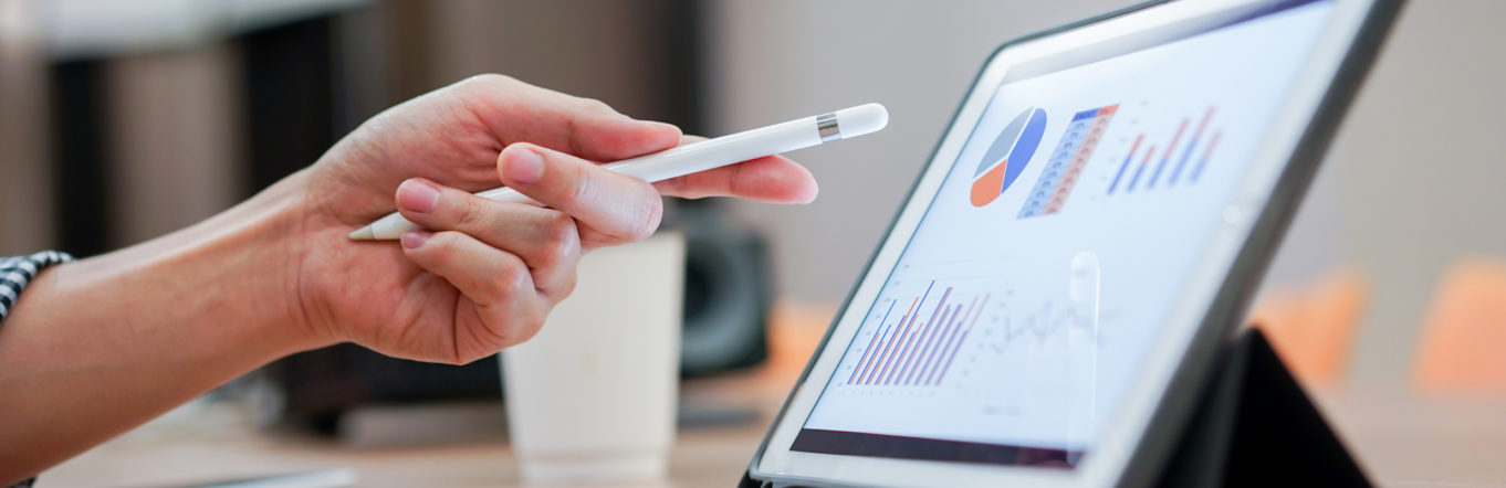 Hand pointing at a graph on a tablet