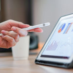 Hand pointing at a graph on a tablet