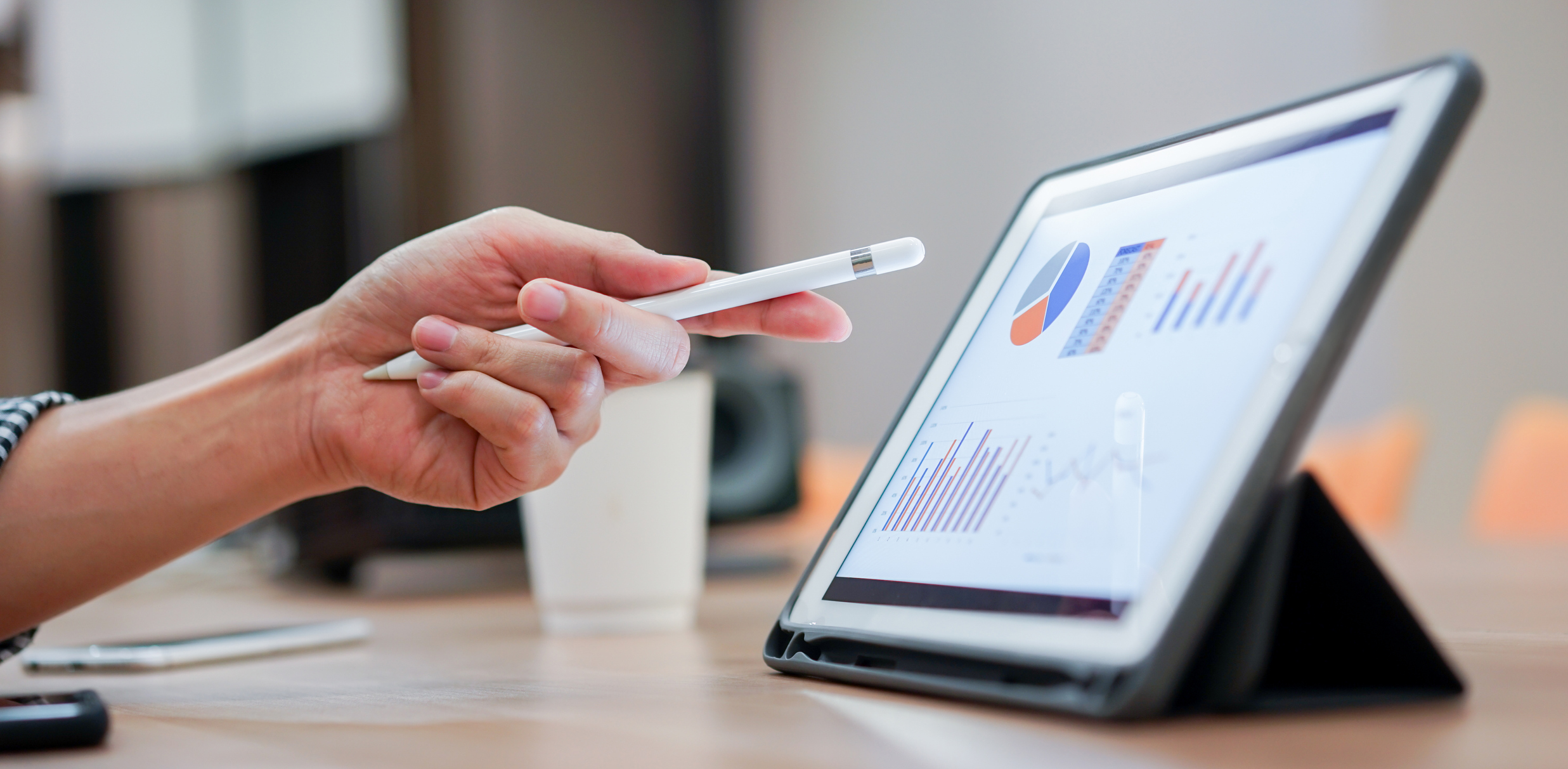 Hand pointing at a graph on a tablet